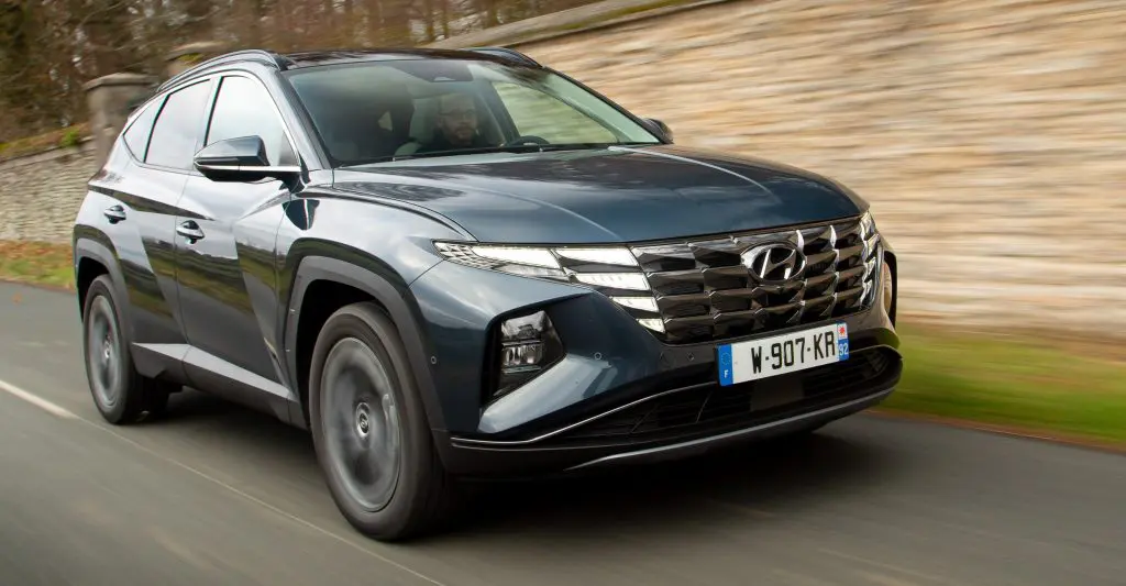hyundai tucson noir en mouvement sur route forestière