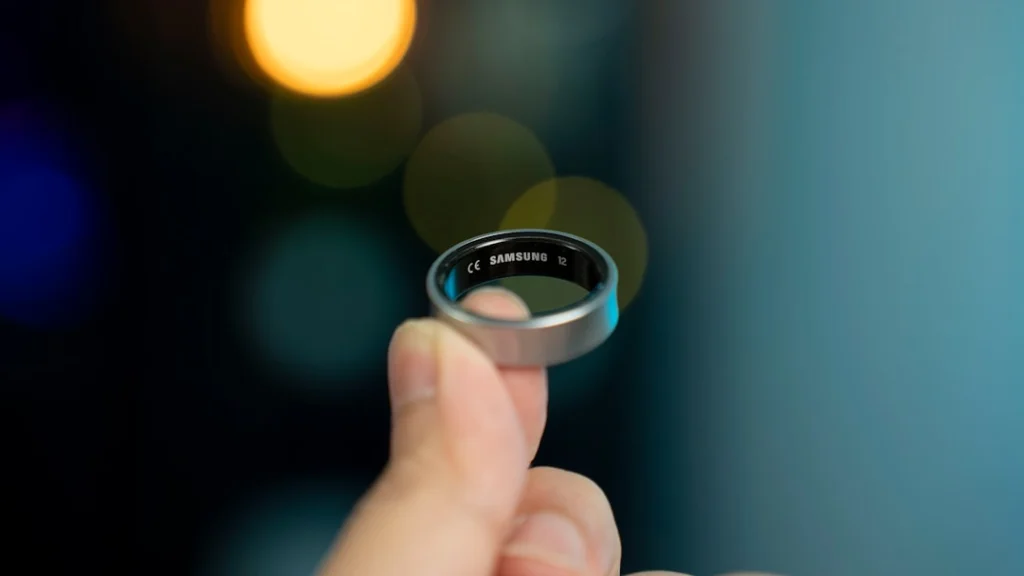 A hand is holding a smart ring.