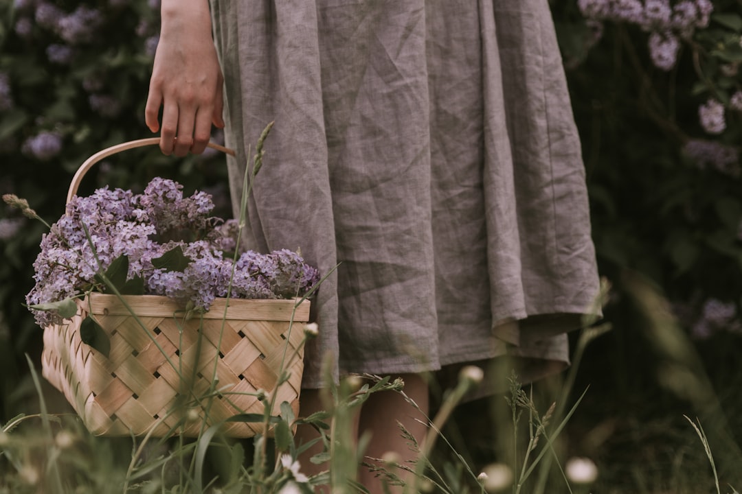 a woman holding a basket with flowers in it